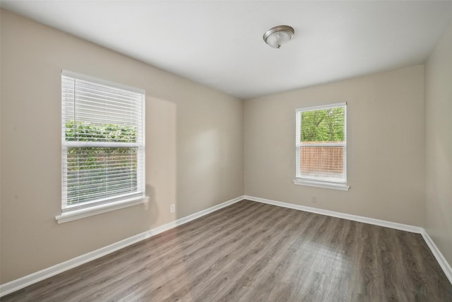 spare room featuring wood finished floors and baseboards