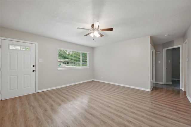 unfurnished living room with light wood finished floors, a ceiling fan, and baseboards