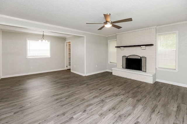 unfurnished living room with wood finished floors, ornamental molding, ceiling fan, a brick fireplace, and a textured ceiling