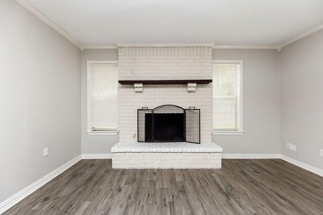 unfurnished living room featuring baseboards, wood finished floors, ornamental molding, and a fireplace