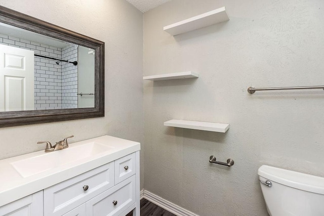 full bathroom with walk in shower, vanity, and toilet