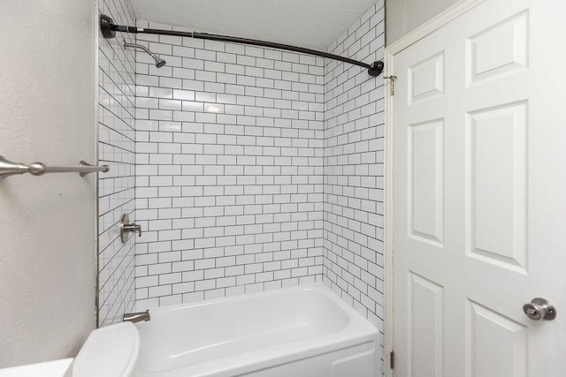 full bath featuring toilet, a textured ceiling, and washtub / shower combination