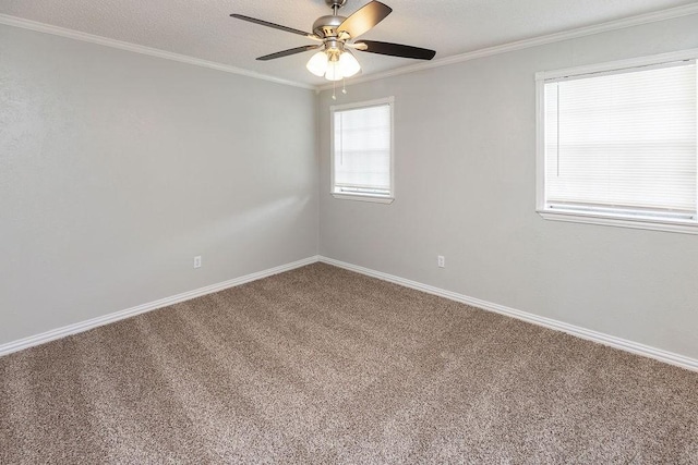 carpeted empty room with ornamental molding, a ceiling fan, and baseboards