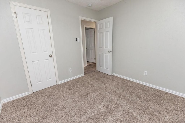 unfurnished bedroom featuring carpet flooring and baseboards