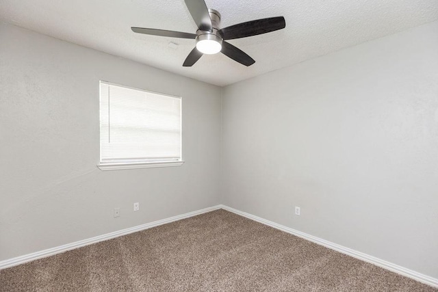 spare room with carpet, a ceiling fan, and baseboards