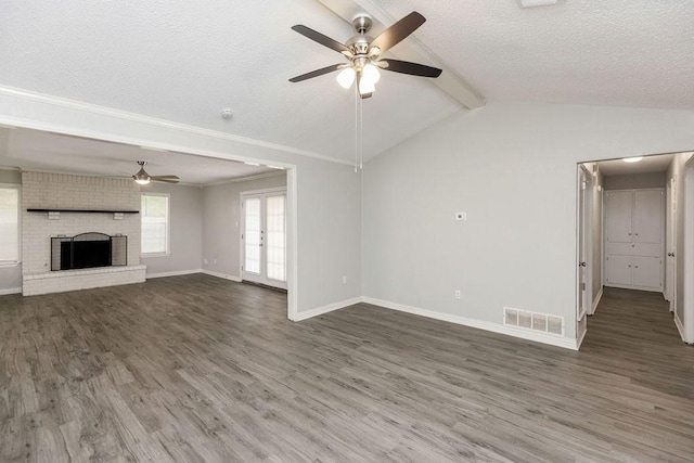 unfurnished living room with ceiling fan, visible vents, baseboards, a textured ceiling, and wood finished floors