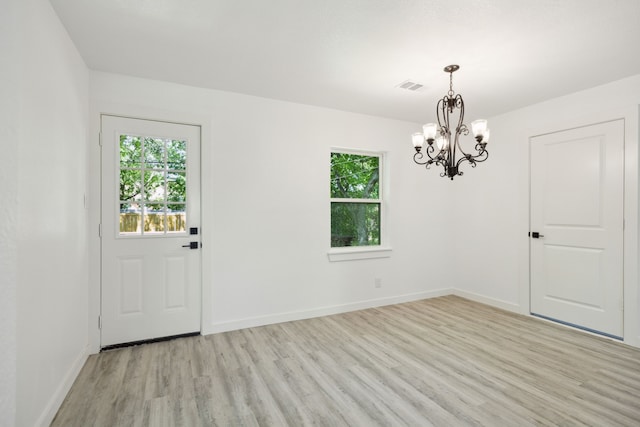 interior space featuring a wealth of natural light, visible vents, a notable chandelier, and light wood-style floors