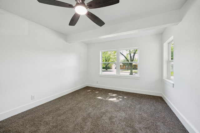 unfurnished room with baseboards, dark carpet, a wealth of natural light, and ceiling fan