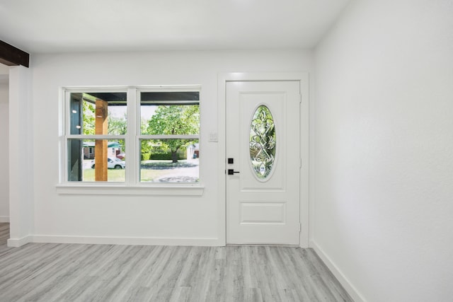 foyer with light wood-style flooring and baseboards