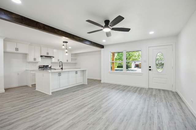 kitchen featuring under cabinet range hood, light countertops, stainless steel range oven, light wood finished floors, and a ceiling fan