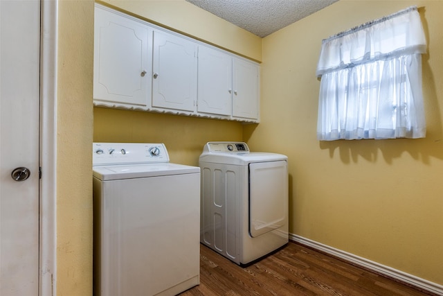 clothes washing area featuring cabinet space, washing machine and clothes dryer, a textured ceiling, and dark wood-type flooring