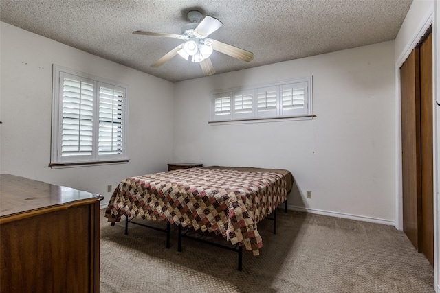 carpeted bedroom featuring a textured ceiling, a ceiling fan, a closet, and baseboards