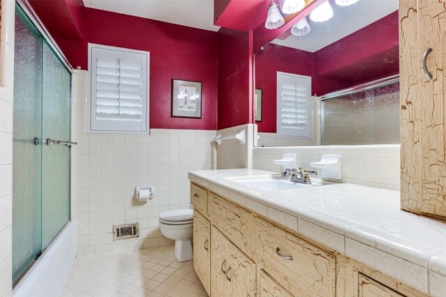 full bath with visible vents, enclosed tub / shower combo, toilet, tile walls, and tile patterned flooring