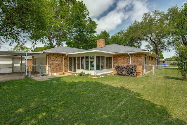 rear view of property with a gate, a yard, a chimney, and brick siding
