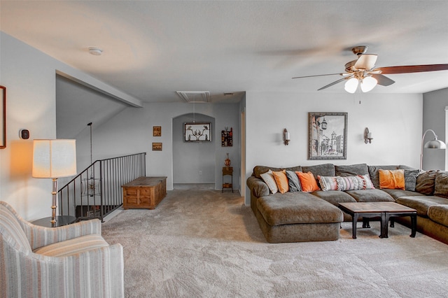 carpeted living area with attic access, a ceiling fan, and visible vents