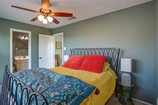 carpeted bedroom featuring a sink, ceiling fan, ensuite bath, visible vents, and baseboards