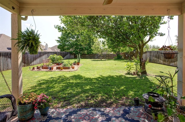 view of yard featuring ceiling fan, a fenced backyard, and a vegetable garden