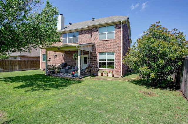 rear view of house with a chimney, a fenced backyard, a patio area, and a lawn