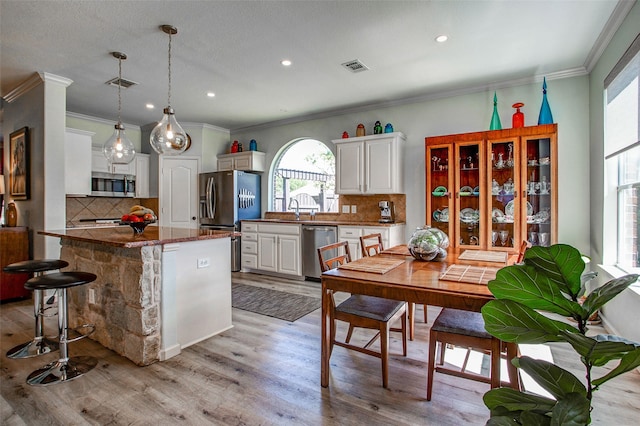 kitchen with visible vents, stainless steel appliances, white cabinets, and decorative backsplash