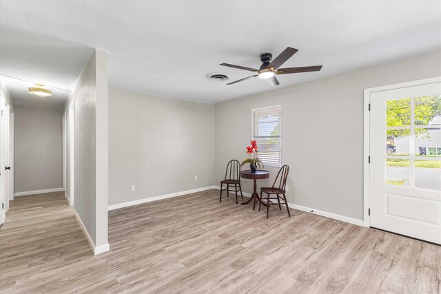 interior space with baseboards, light wood-type flooring, and ceiling fan