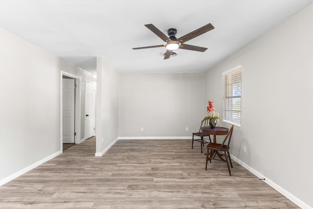 sitting room featuring wood finished floors, a ceiling fan, and baseboards