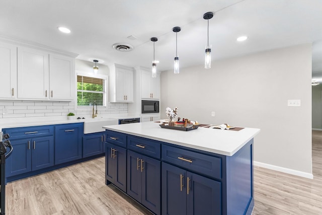 kitchen with black appliances, blue cabinetry, white cabinets, and a sink