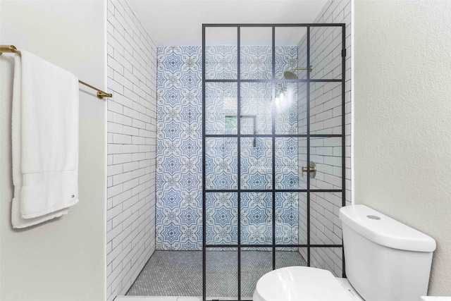 full bathroom with walk in shower, toilet, and a textured wall
