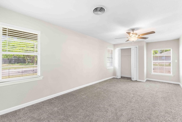 unfurnished bedroom featuring carpet flooring, visible vents, a closet, baseboards, and a ceiling fan
