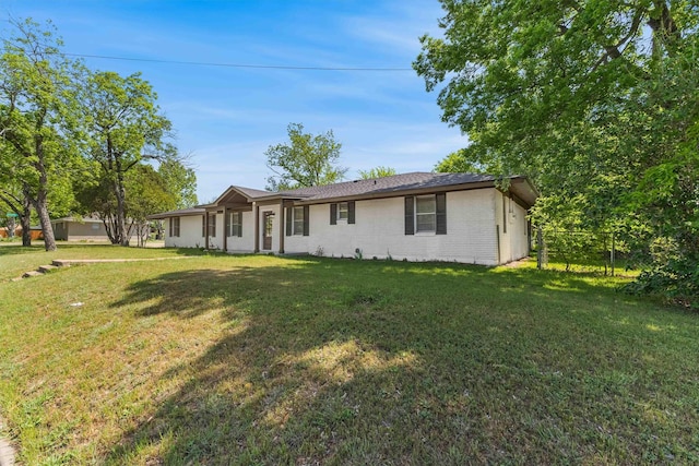 ranch-style house featuring brick siding, fence, and a front yard