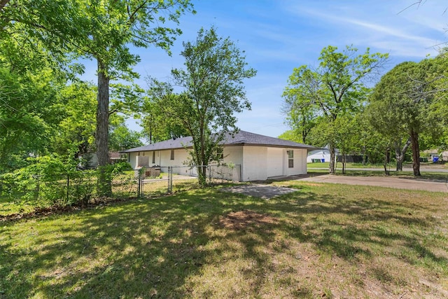 view of yard with driveway and fence