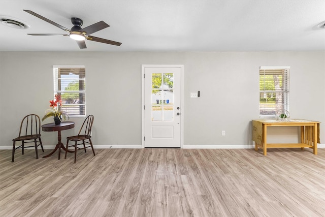 foyer with wood finished floors, ceiling fan, plenty of natural light, and visible vents