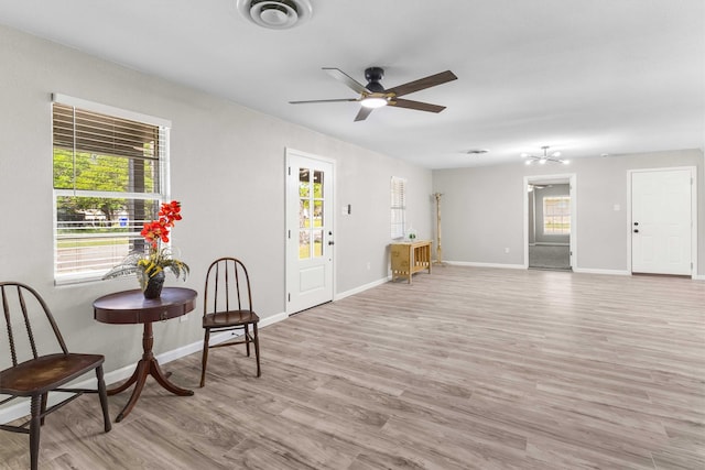 sitting room featuring visible vents, ceiling fan, baseboards, and light wood-style floors