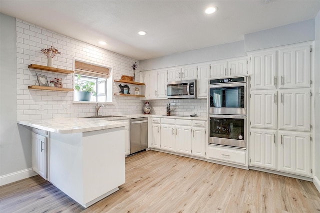 kitchen featuring a sink, white cabinets, open shelves, and stainless steel appliances
