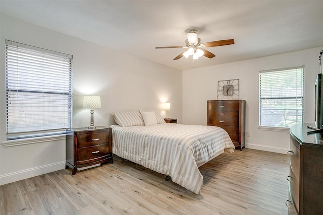 bedroom with a ceiling fan, light wood-style flooring, and baseboards