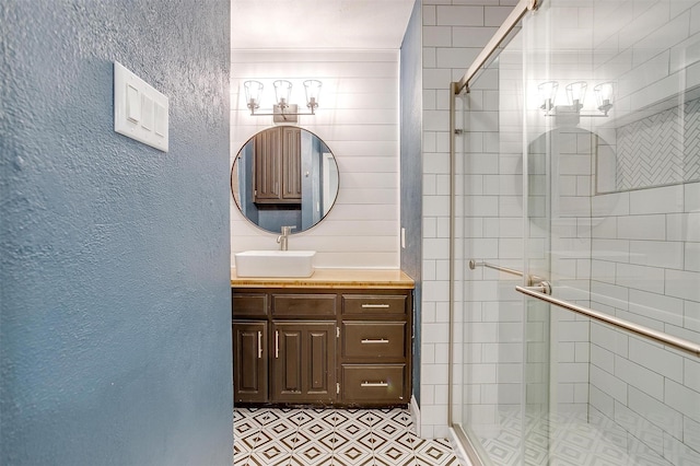 bathroom with tile patterned floors, a shower stall, and vanity