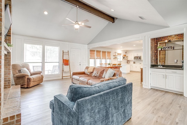 living room featuring beamed ceiling, light wood-style floors, ceiling fan, high vaulted ceiling, and visible vents