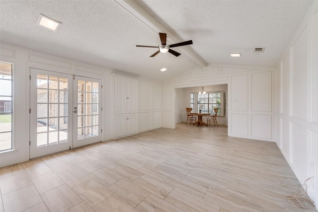 unfurnished room with a textured ceiling, a decorative wall, french doors, and a ceiling fan
