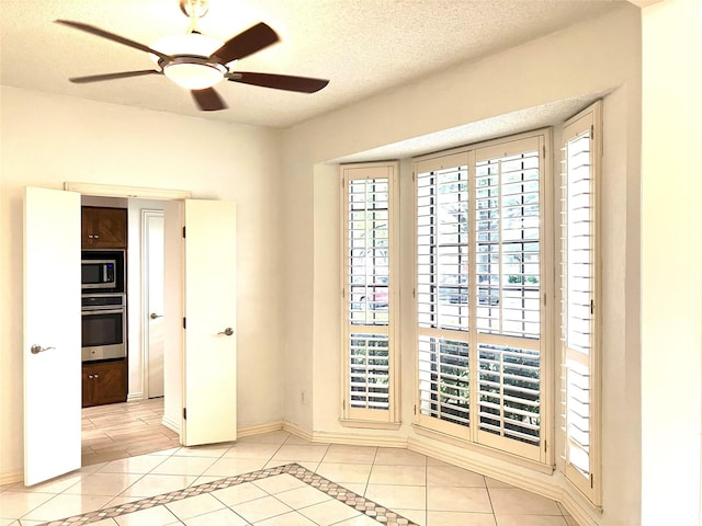 912 E Berkeley Dr, Richardson, TX 75081 - empty room with light tile patterned floors, baseboards, ceiling fan, inlaid floor details, and a textured ceiling
