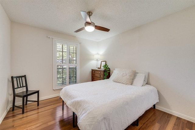 bedroom featuring a textured ceiling, ceiling fan, wood finished floors, and baseboards