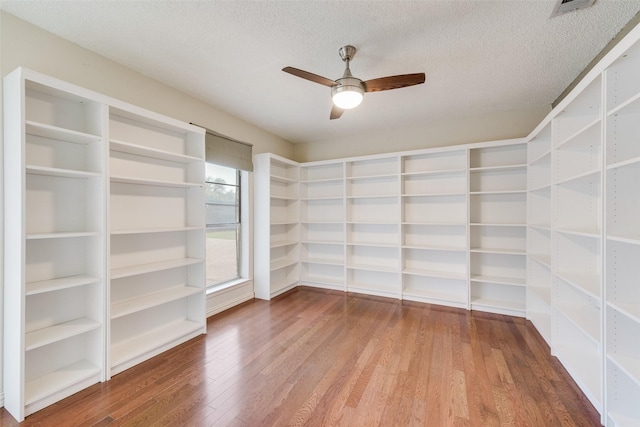 spare room featuring wood finished floors, a ceiling fan, and a textured ceiling