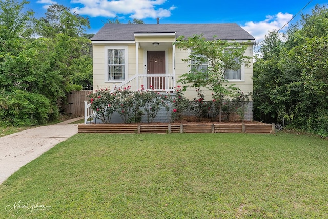 view of front of home featuring fence, a front lawn, and roof with shingles