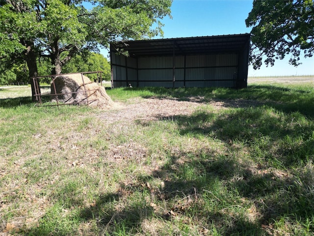 view of yard featuring a carport and an outbuilding