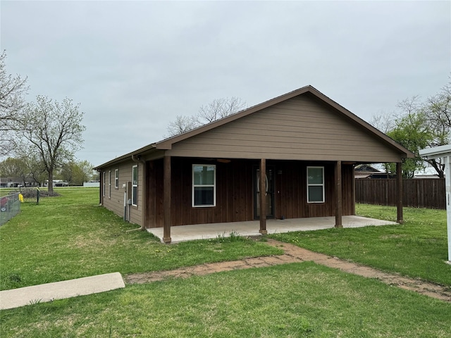 view of front facade featuring fence, a front lawn, and a patio area