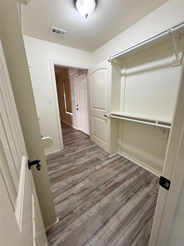 spacious closet with visible vents and wood finished floors