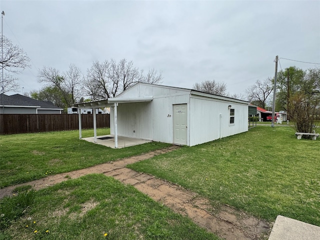 view of outdoor structure with fence and a carport