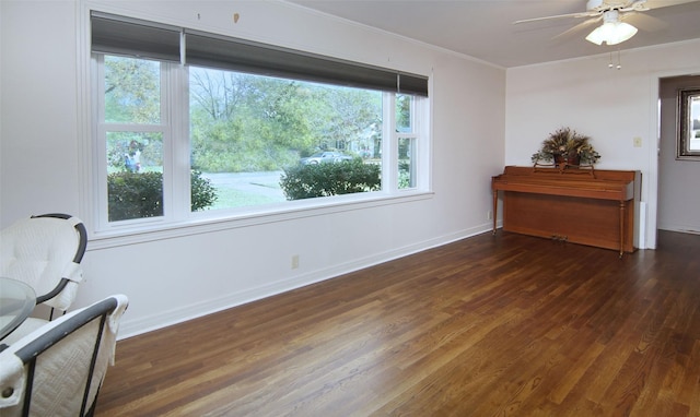 sitting room featuring wood finished floors, ceiling fan, crown molding, and baseboards