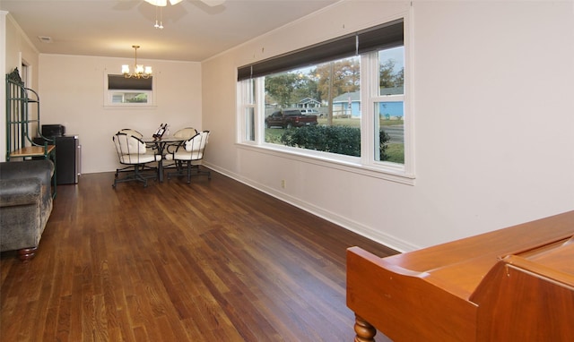 dining space with ornamental molding, baseboards, wood finished floors, and ceiling fan with notable chandelier