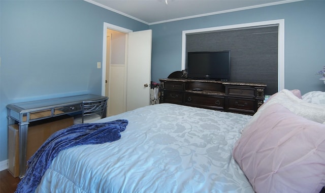 bedroom with wood finished floors, crown molding, and baseboards