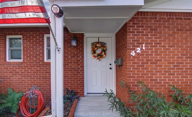 view of exterior entry featuring brick siding