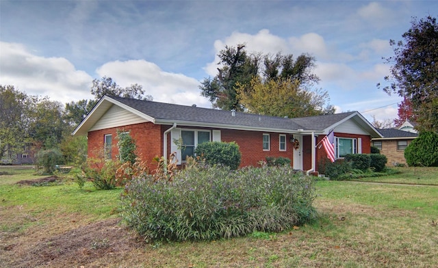 ranch-style home with a front yard and brick siding